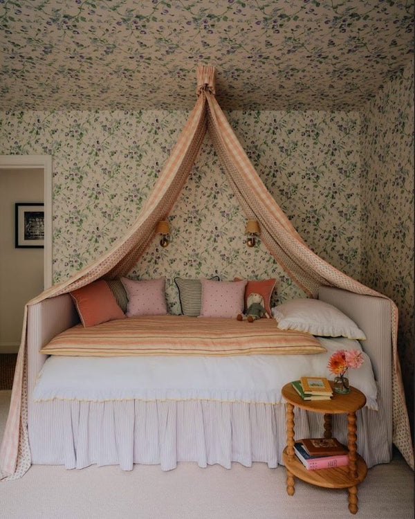 Bed with canopy and floral wallpaper in a bedroom setting